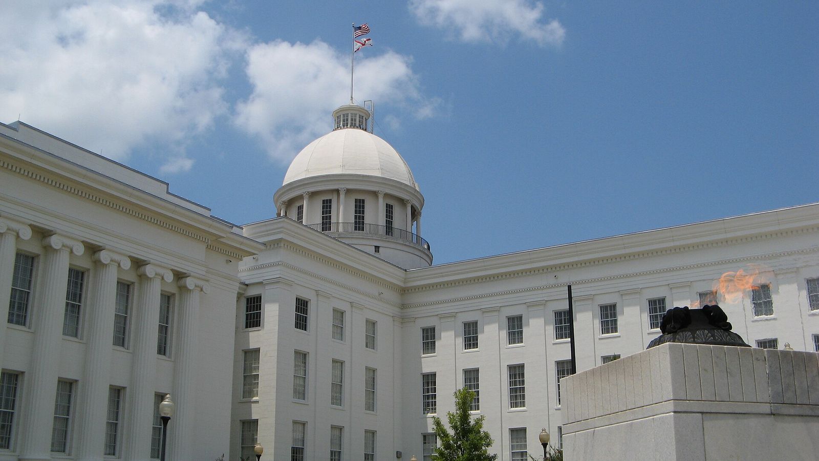 The white domed Alabama State Capitol in Montgomery beside the eternal flame of the Alabama Veterans Memorial