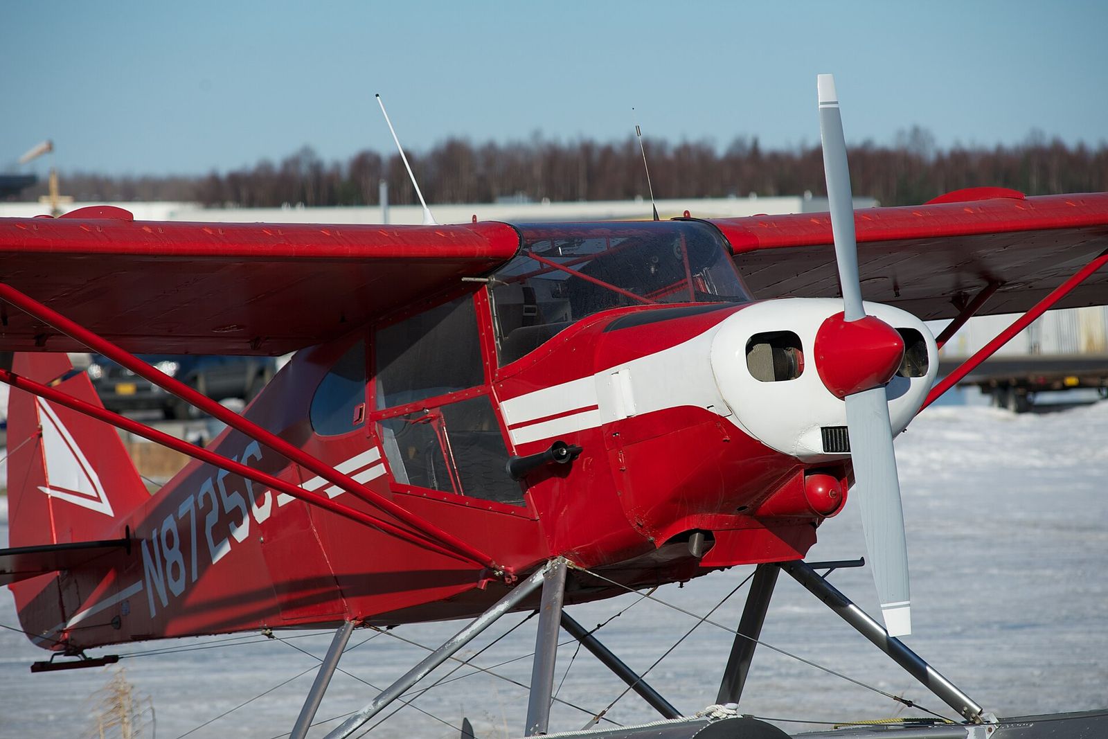A red and white 1956 Piper Tri-Pacer on floats waiting out the winter at Lake Hood Seaplane Base in Anchorage
