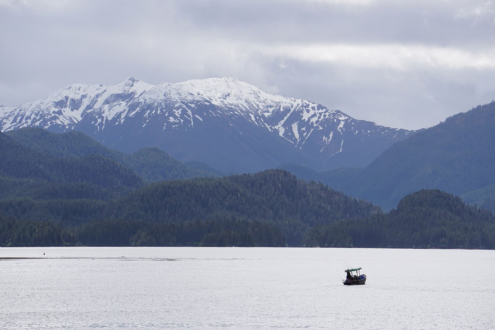 A small boat on Sitka Sound below snow-capped mountains
