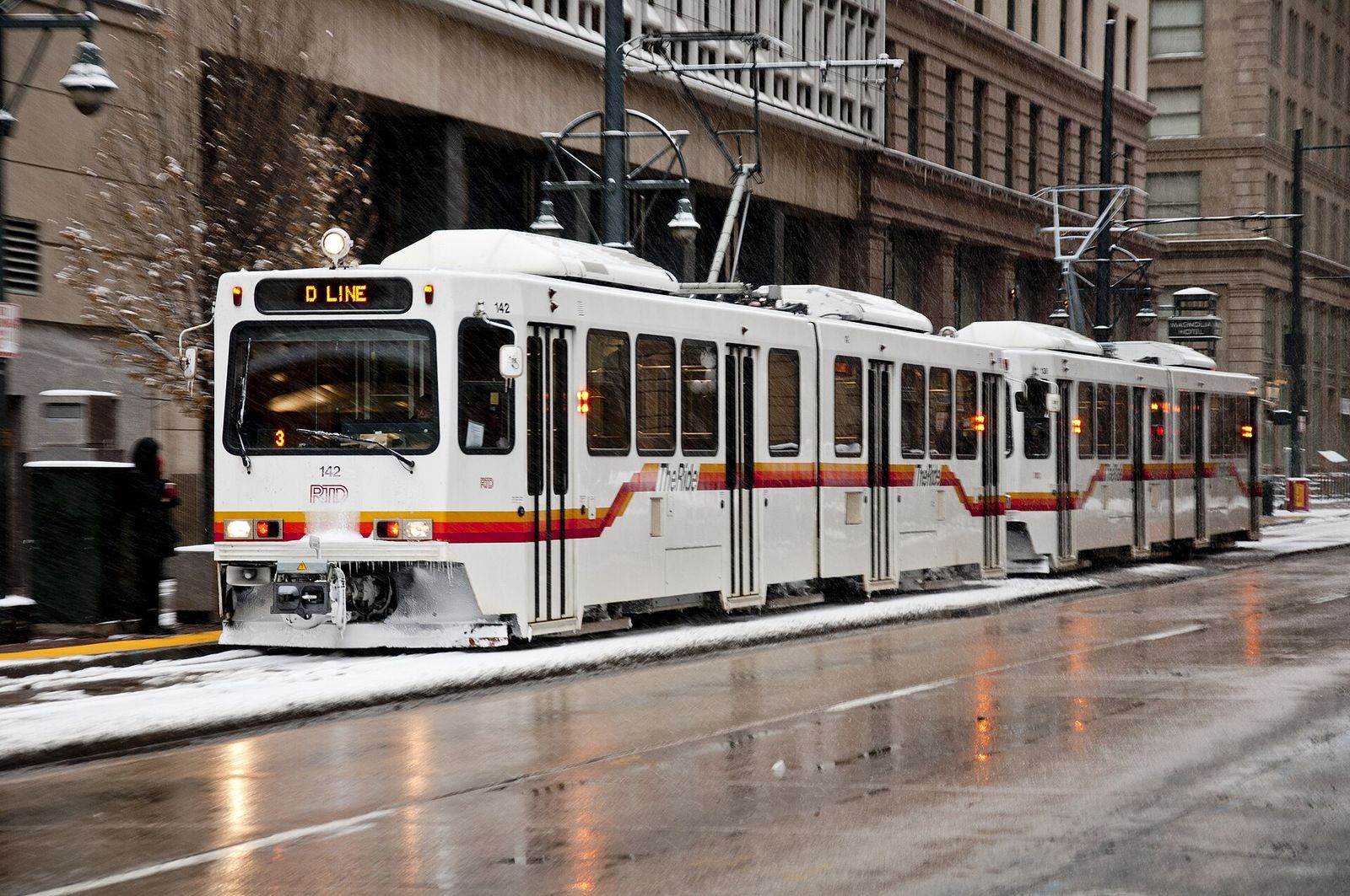 An RTD light rail train on Stout Street in downtown Denver after a snowfall