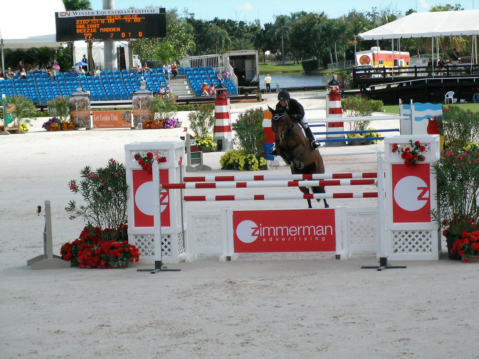 Beezie Madden and the horse Onlight clearing a red and white fence in the Grand Prix at the 2008 Winter Equestrian Festival in Wellington