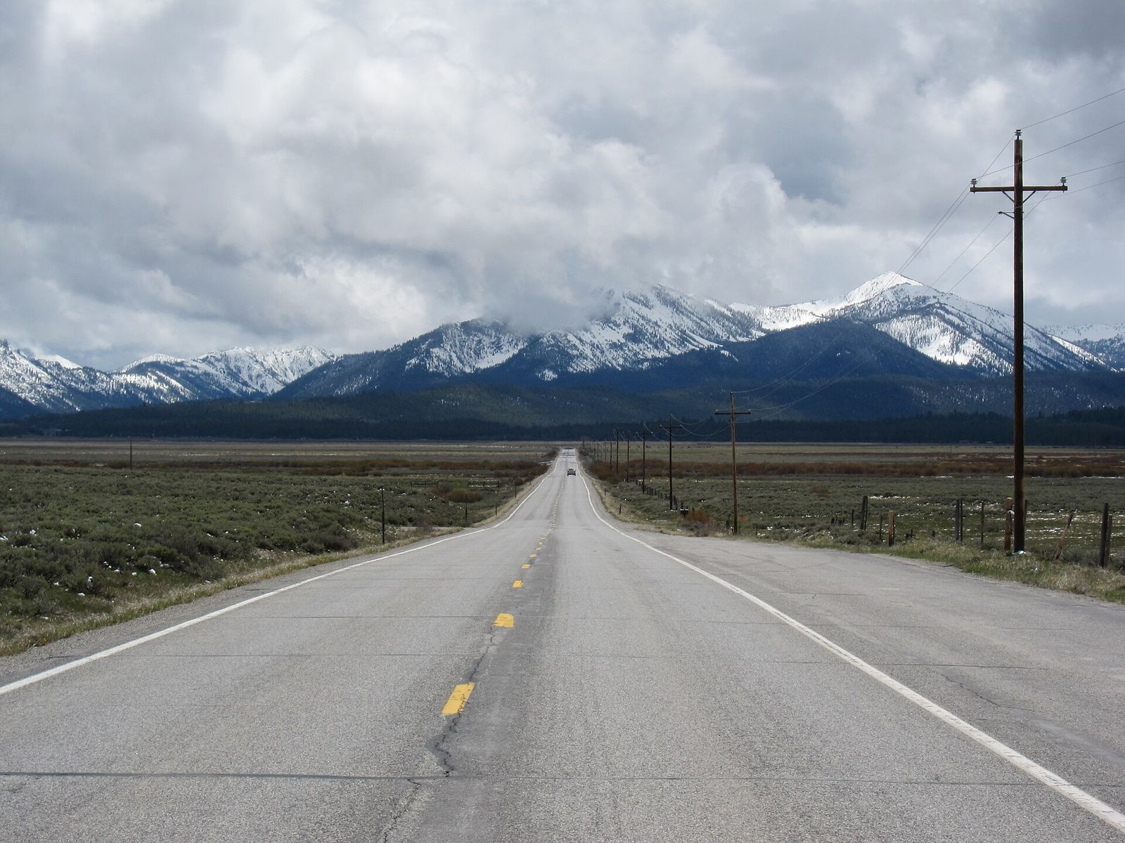 Idaho State Highway 75 running straight across the Sawtooth Valley toward snow-capped mountains