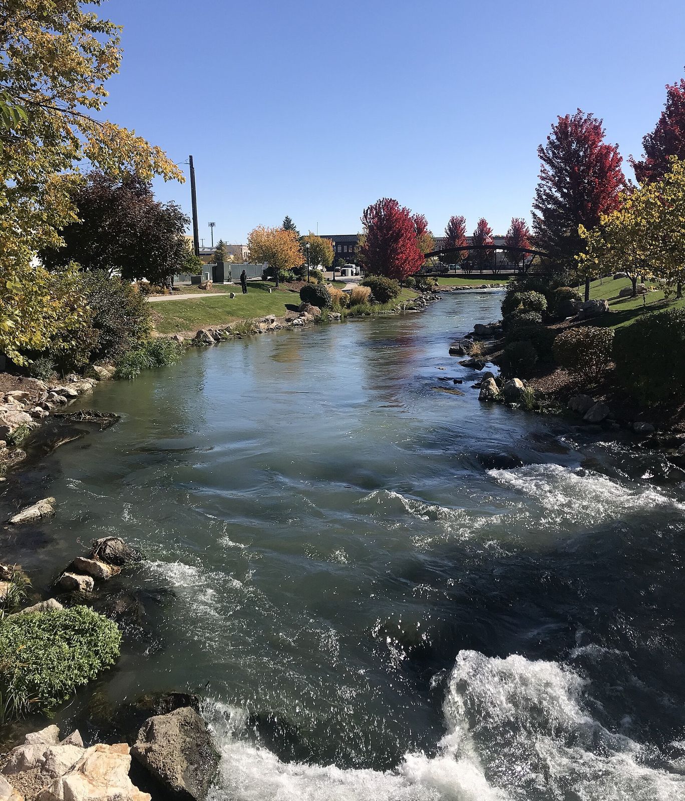 Indian Creek flowing past rocks and autumn trees in a park in downtown Caldwell