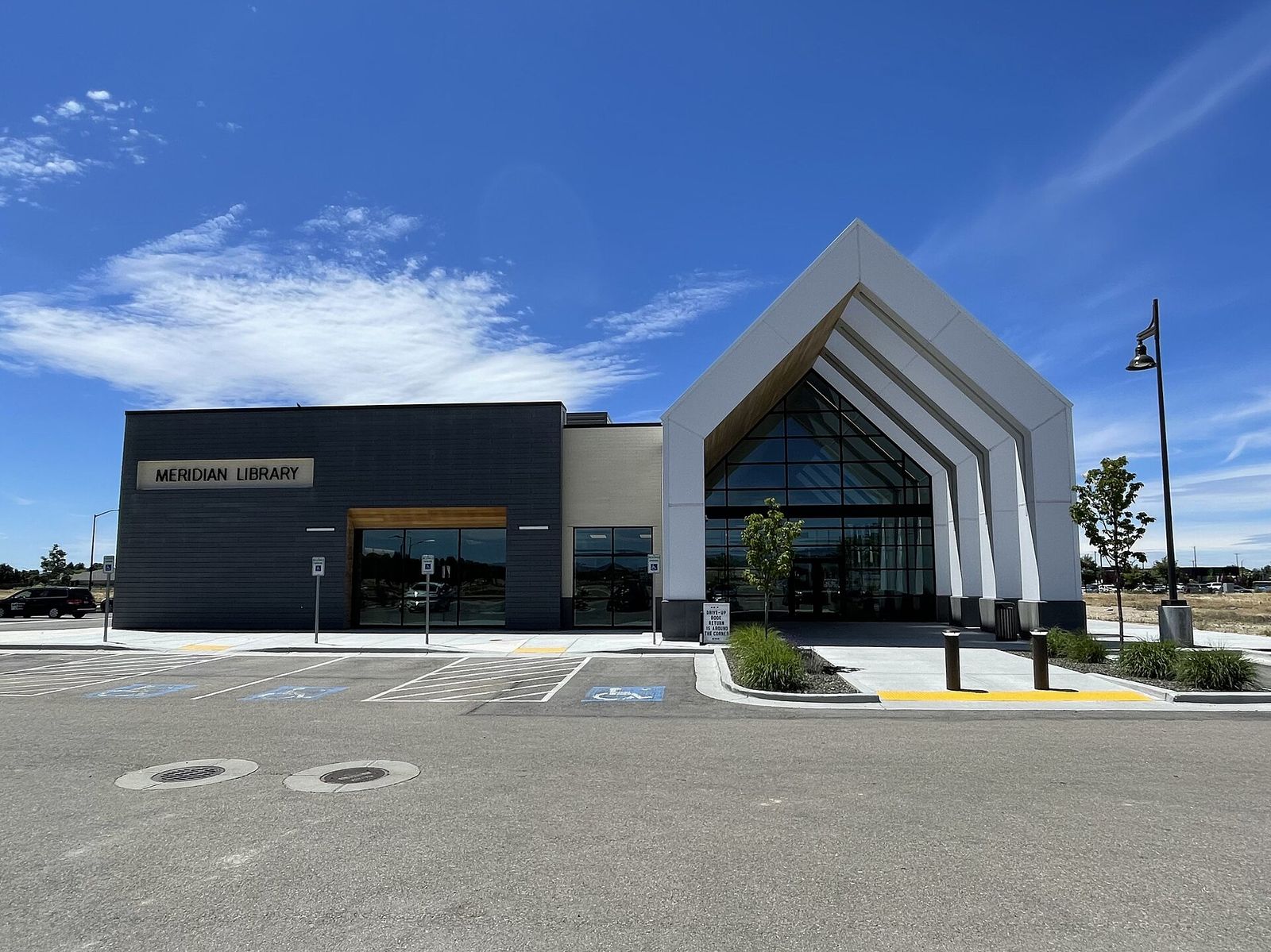 The modern Meridian Library at Orchard Park, with a tall peaked roof and a glass front