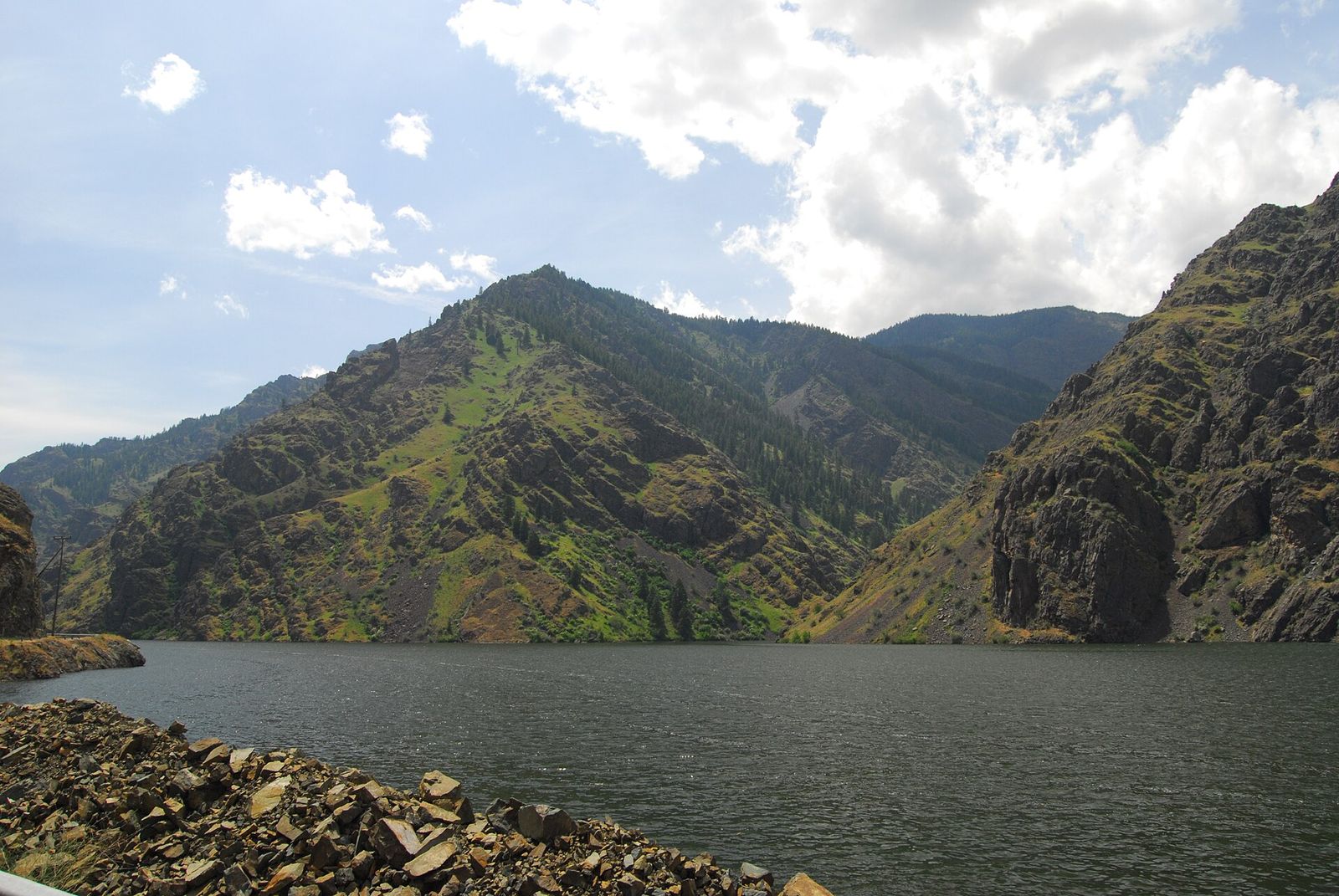 The Snake River in Hells Canyon between steep green mountainsides