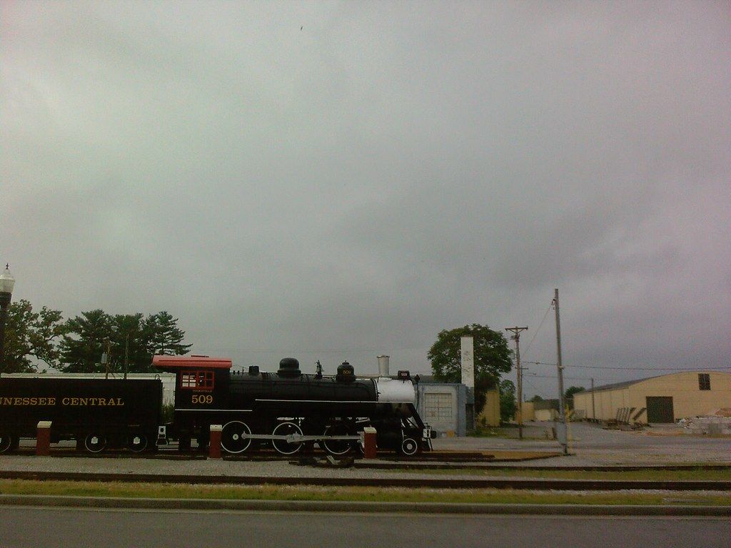 A preserved steam locomotive on display in Cookeville under a gray sky