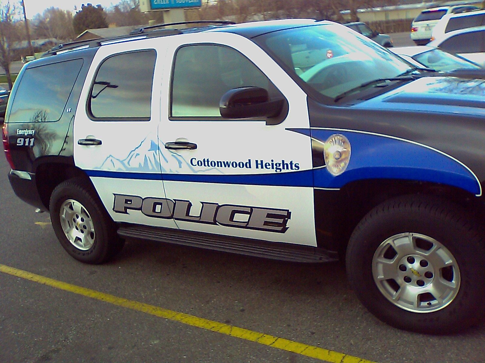 A white Cottonwood Heights Police SUV with the city's mountain logo on its door