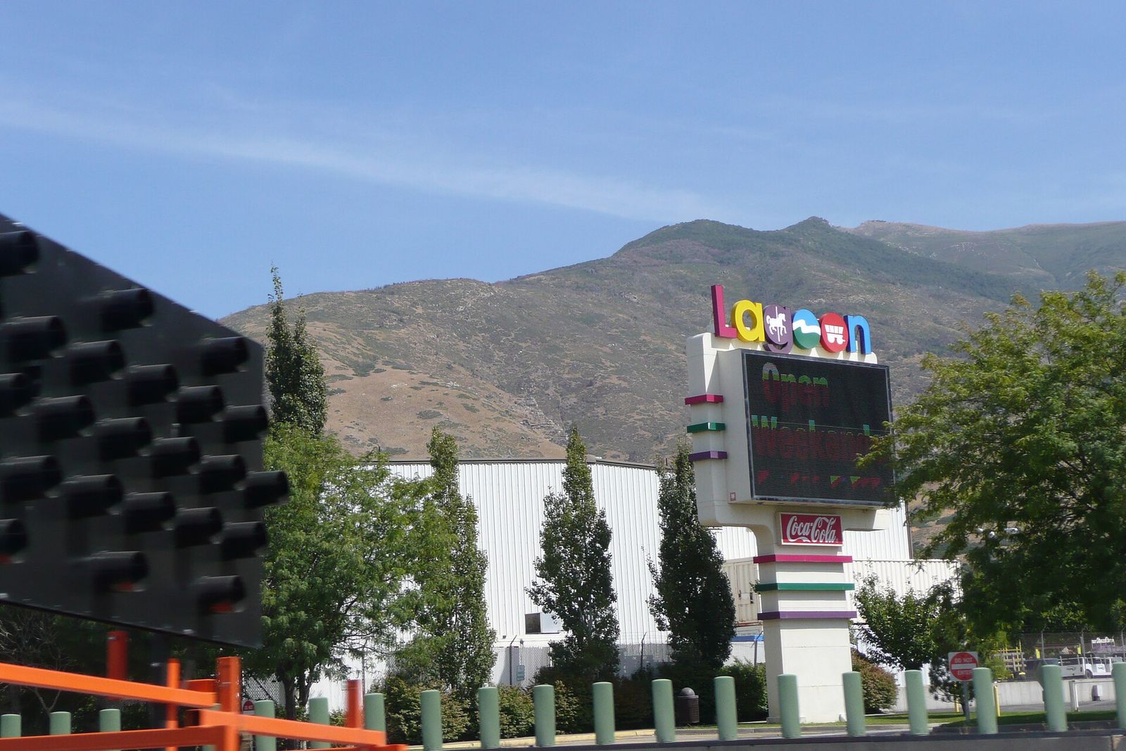 The Lagoon sign and rides at the amusement park in Farmington, with the Wasatch foothills behind
