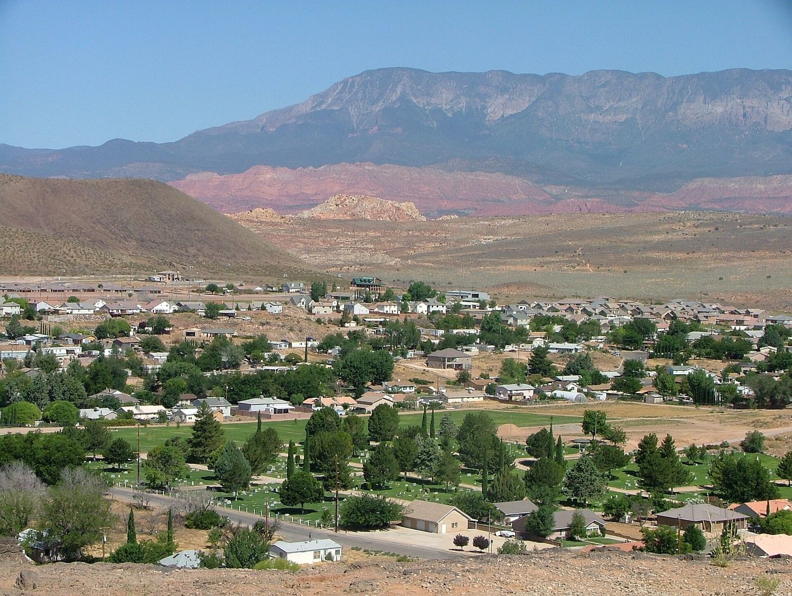 Hurricane's tree-lined neighborhoods spread across the valley below red hills and a long mesa