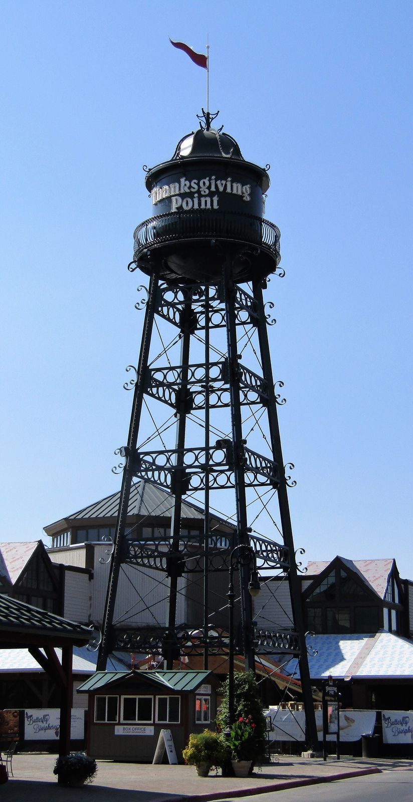 The black lattice water tower at Thanksgiving Point against a blue sky
