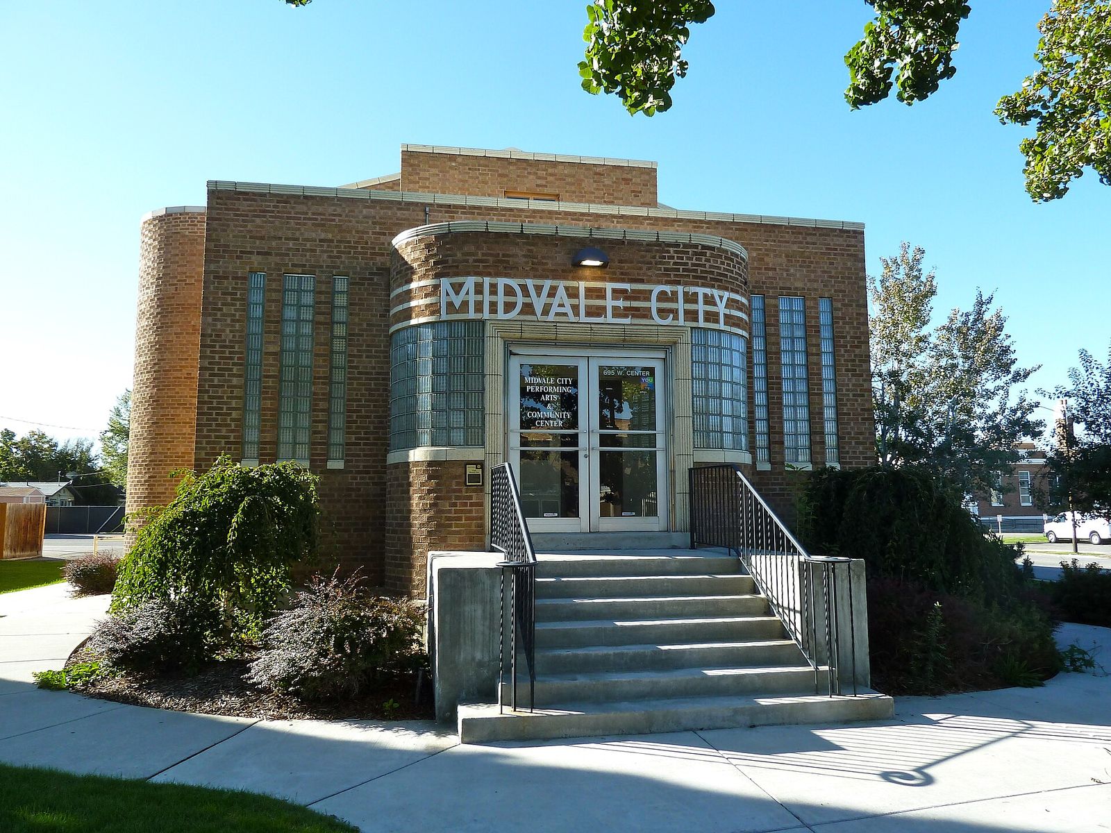 The historic brick Midvale City Hall with its name above the entrance and front steps