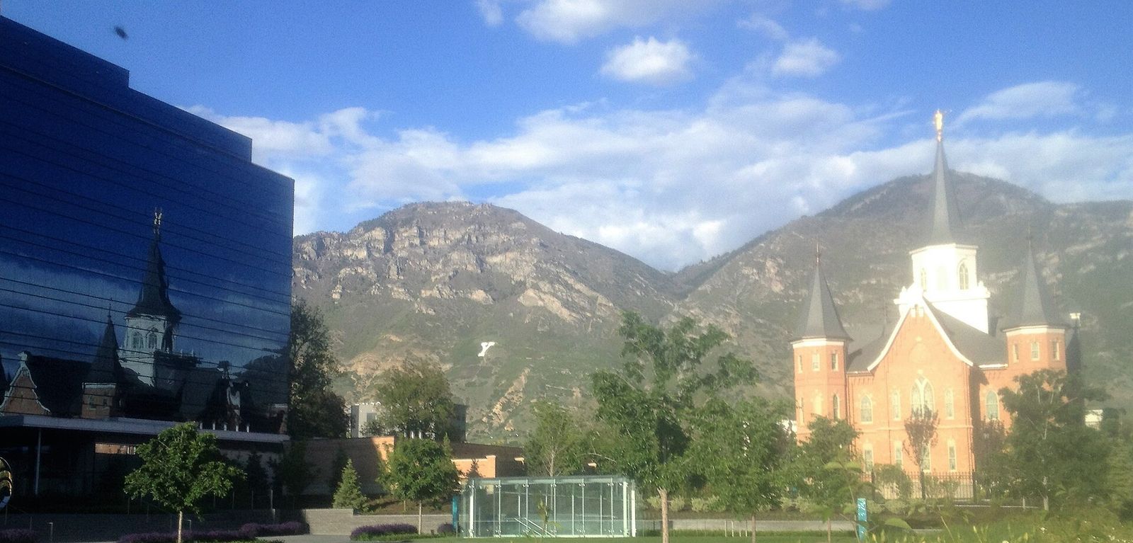 The Provo City Center Temple reflected in the glass of a nearby office building