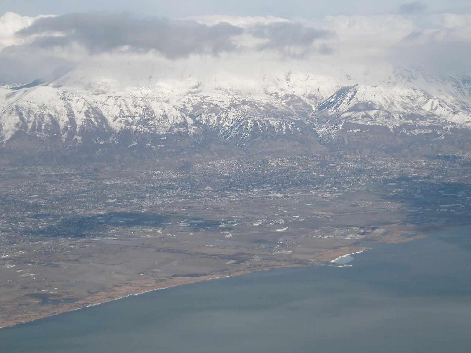 Utah Lake and the northern Utah Valley from the air, with Mount Timpanogos and snowy peaks beyond
