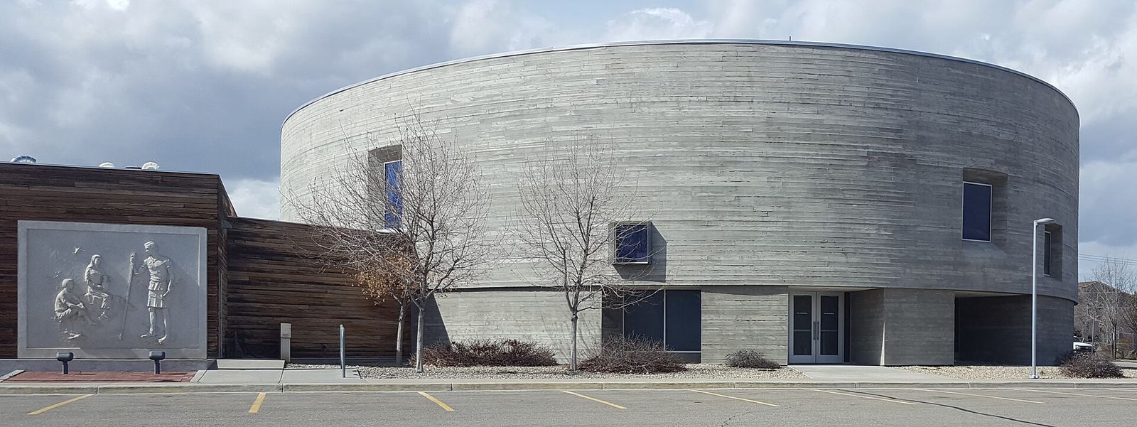 The round concrete Saint Joseph the Worker Catholic Church in West Jordan under a light sky